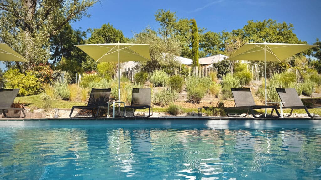 Piscine chauffée extérieure de Kassiopée Bed & Spa, vue panoramique sur le jardin paysager de 5 000 m² avec la maison d'hôtes Adult Only en arrière-plan, à Albi
